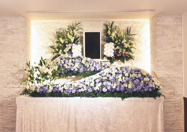 春日部市にある家族葬のアート春日部の式場にて白と紫の花祭壇を設置した様子