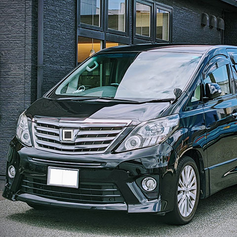 家族葬のアートの黒い霊柩車と式場前の風景