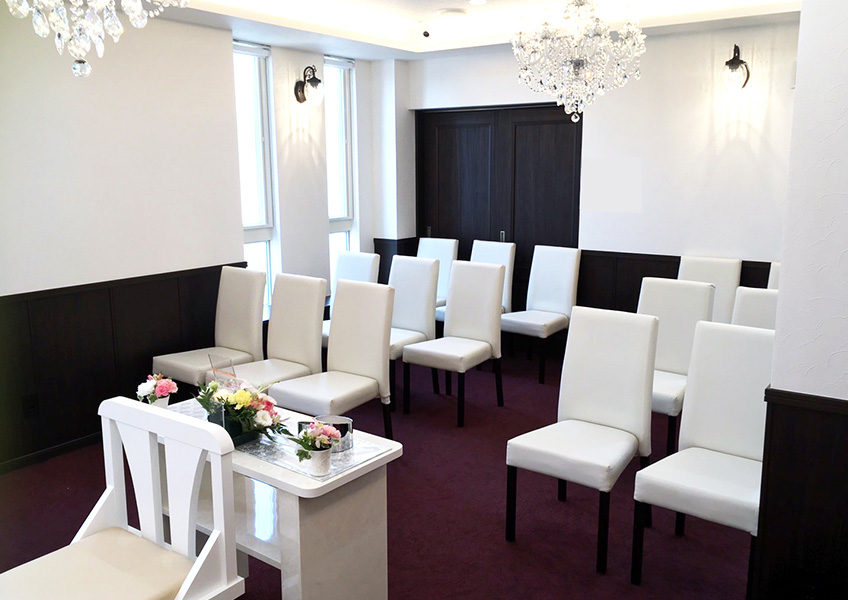 草加市にある家族葬のアート草加氷川ホールの白い椅子が並ぶ式場