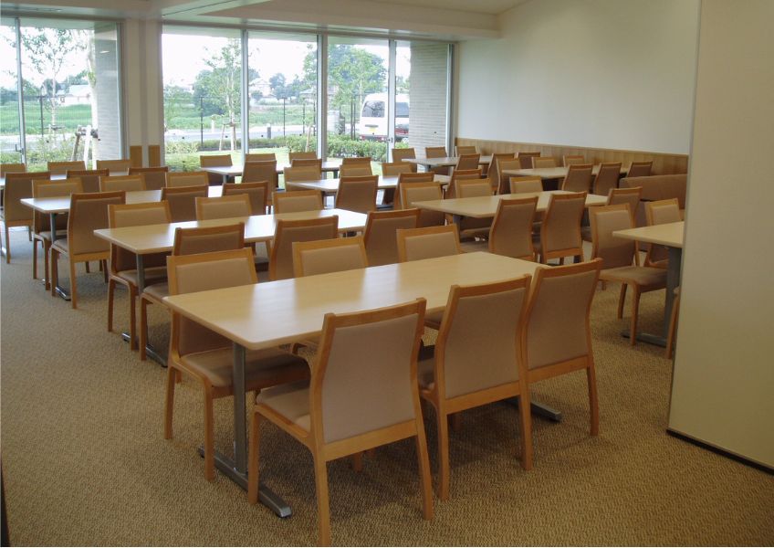 越谷市斎場の明るい待合室に並ぶ椅子とテーブル