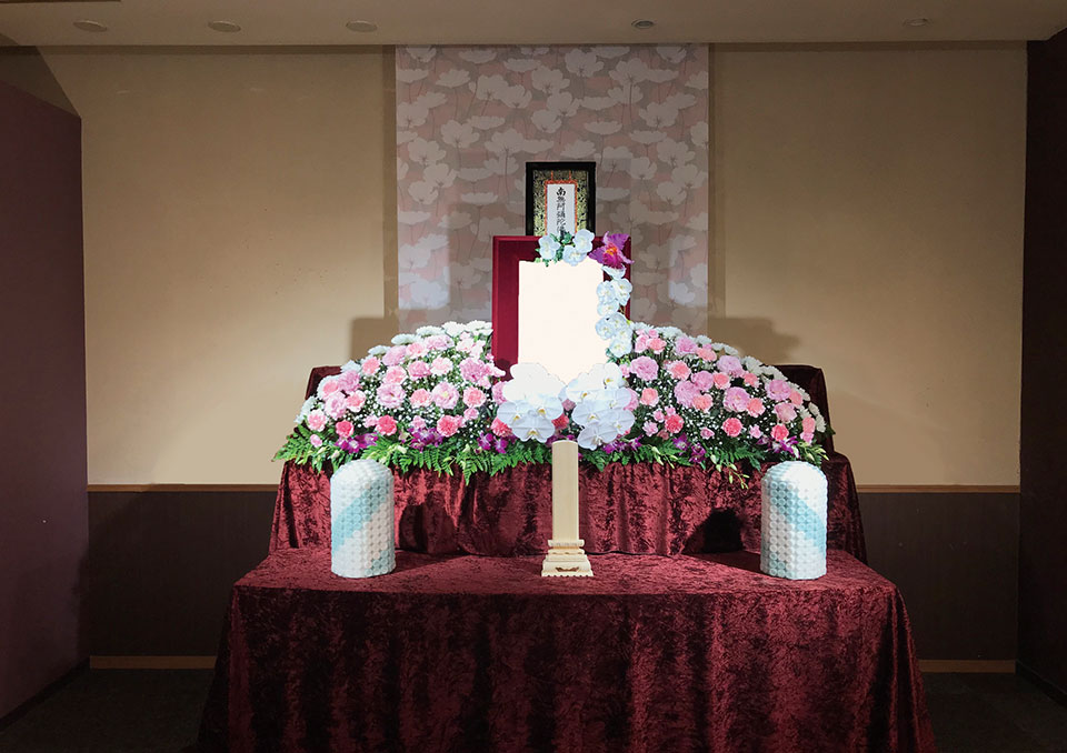 越谷市にある家族葬のアート越谷駅前の白・ピンクの生花祭壇と遺影壇