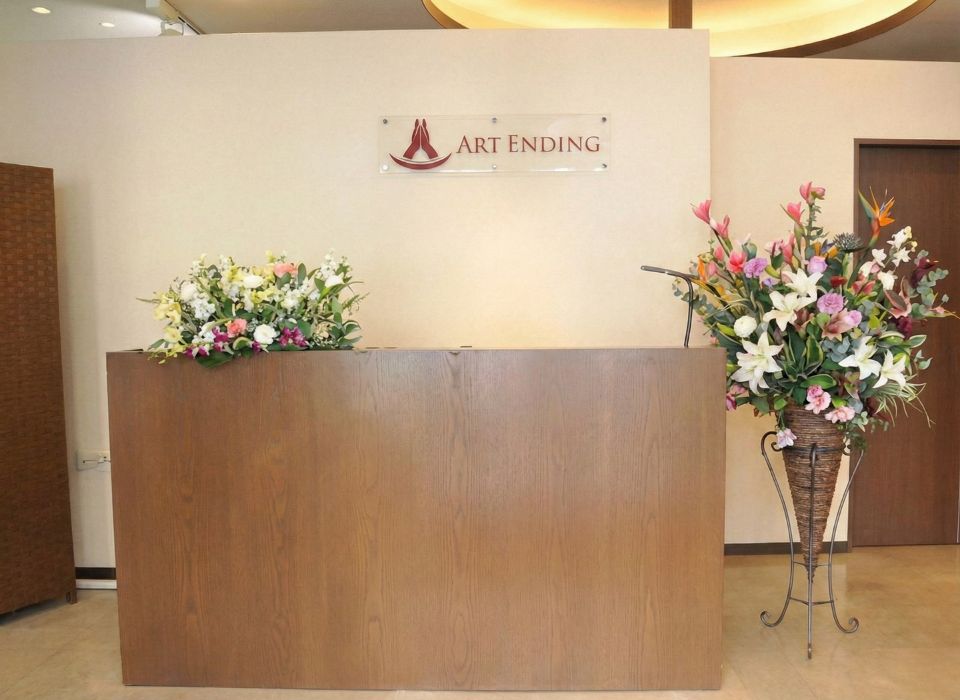 家族葬のアートの越谷市式場受付に飾られた白とピンクの生花アレンジメント